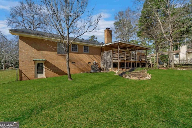 rear view of house featuring a chimney, crawl space, fence, a yard, and brick siding