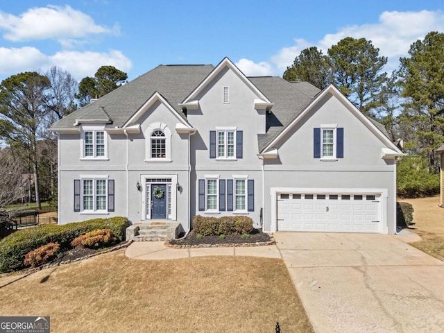 view of front of house featuring driveway, an attached garage, and stucco siding