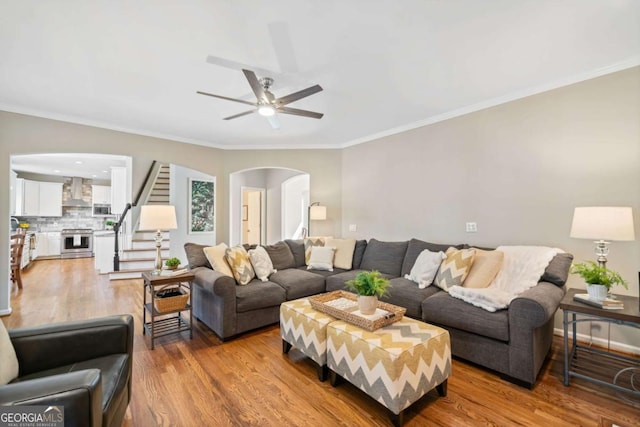 living area with stairway, wood finished floors, and ornamental molding