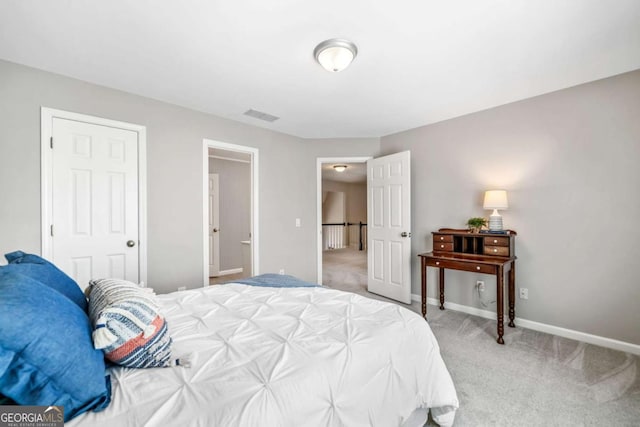 bedroom with baseboards, visible vents, and light colored carpet