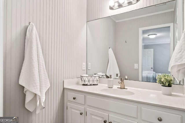 bathroom with ornamental molding, connected bathroom, and vanity