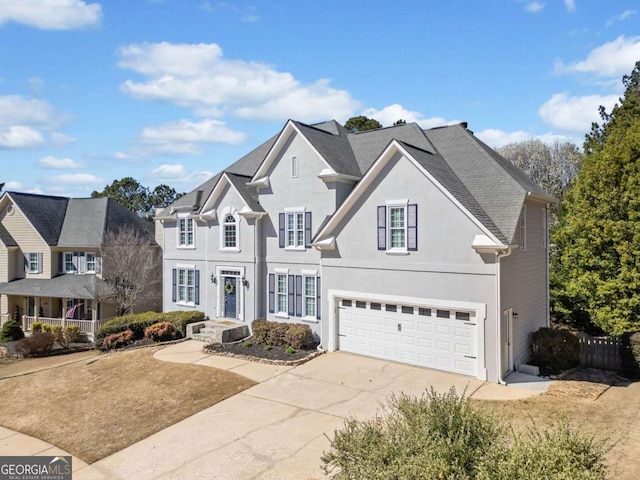 traditional home featuring a garage, concrete driveway, and stucco siding