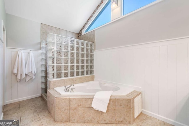 full bath featuring wainscoting, lofted ceiling, tile patterned floors, a garden tub, and a walk in shower