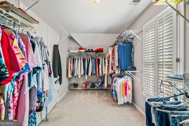 spacious closet featuring carpet floors, visible vents, and vaulted ceiling