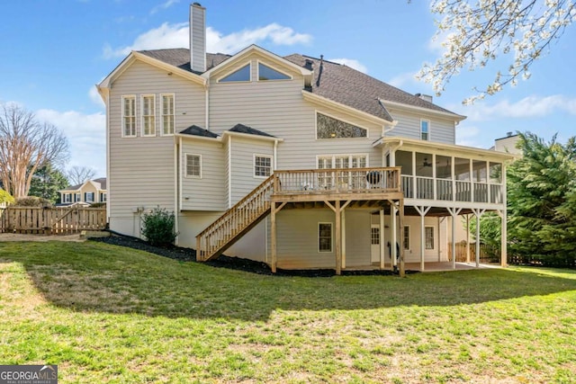 rear view of house featuring a patio, a sunroom, a lawn, stairway, and a chimney