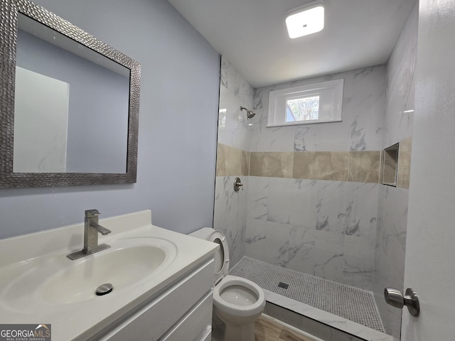 bathroom with a stall shower, vanity, and toilet