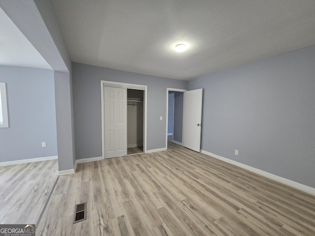 unfurnished bedroom featuring light wood-type flooring, baseboards, and visible vents