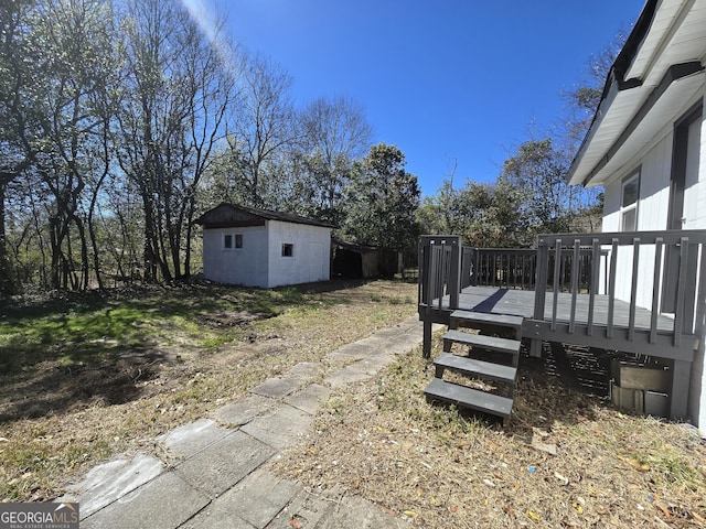 view of yard with a wooden deck and an outbuilding