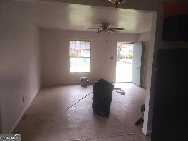 interior space with baseboards and a ceiling fan