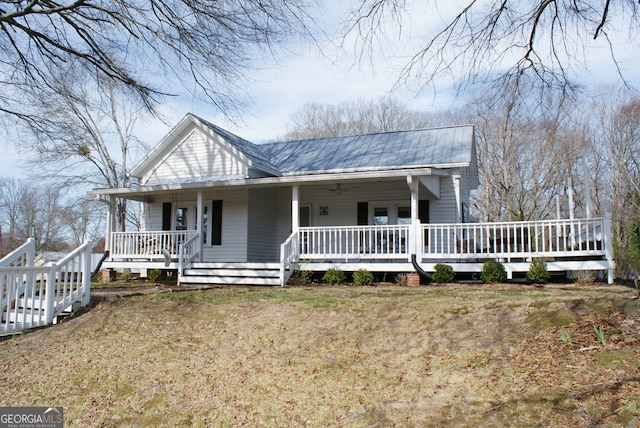 farmhouse inspired home with a porch, a front lawn, and metal roof