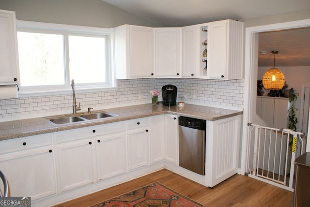 kitchen featuring stainless steel dishwasher, white cabinets, light wood finished floors, and a sink