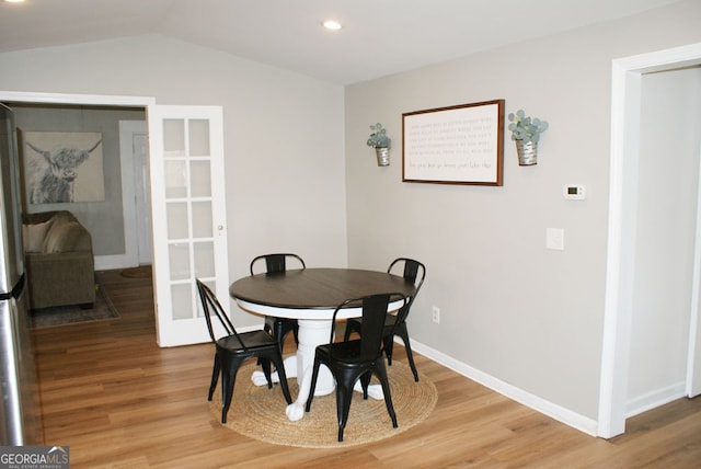 dining room featuring recessed lighting, french doors, baseboards, light wood-style floors, and lofted ceiling