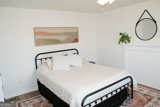 bedroom featuring visible vents, baseboards, and wood finished floors