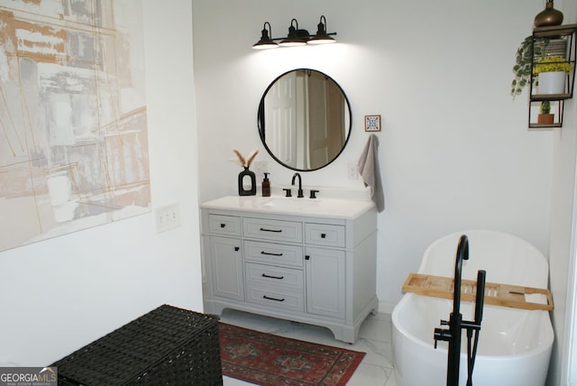 full bathroom with vanity, a freestanding tub, and marble finish floor