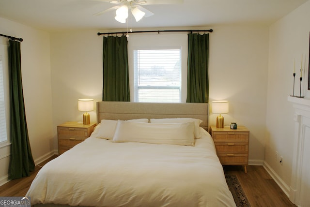 bedroom featuring ceiling fan, baseboards, and wood finished floors