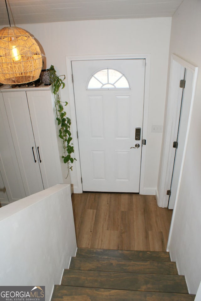 entryway with wood finished floors and stairs