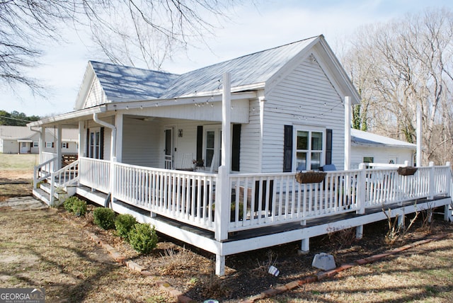 view of property exterior with metal roof and a porch