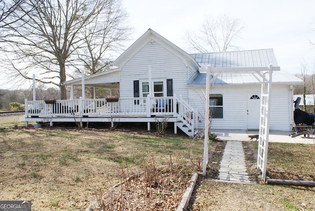 rear view of house with a patio area, a yard, metal roof, and a deck