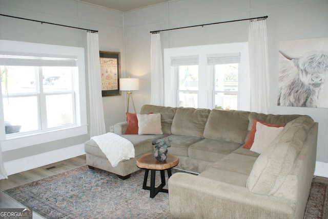 living area with visible vents, baseboards, and wood finished floors