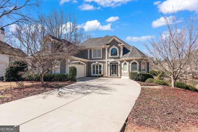 view of front facade featuring stucco siding, concrete driveway, and a garage