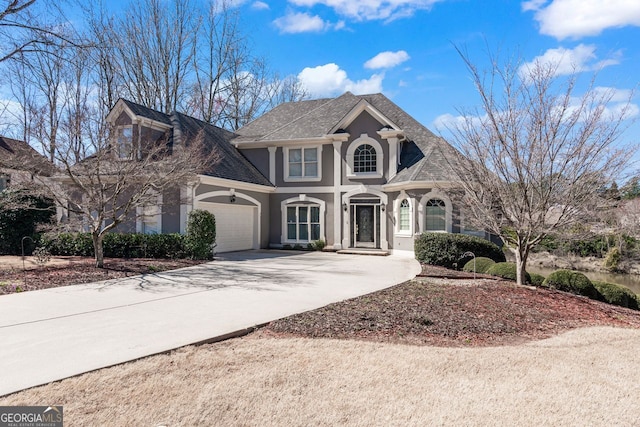 view of front of property featuring a garage, driveway, and stucco siding