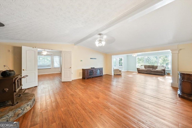 living room with lofted ceiling with beams, light wood finished floors, ceiling fan, and a textured ceiling