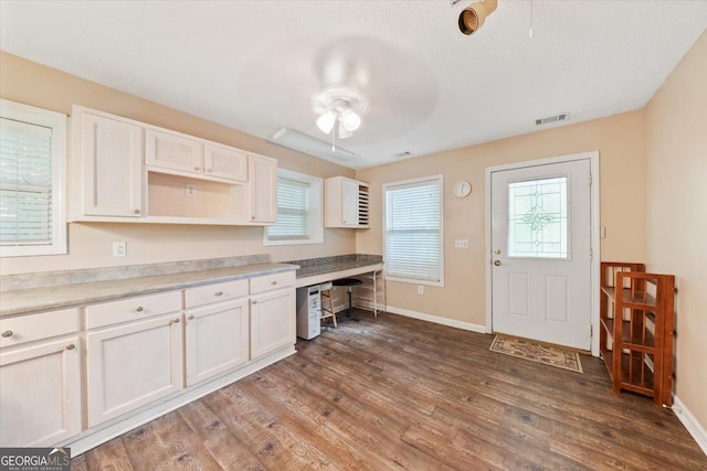 kitchen featuring white cabinets, visible vents, ceiling fan, and wood finished floors