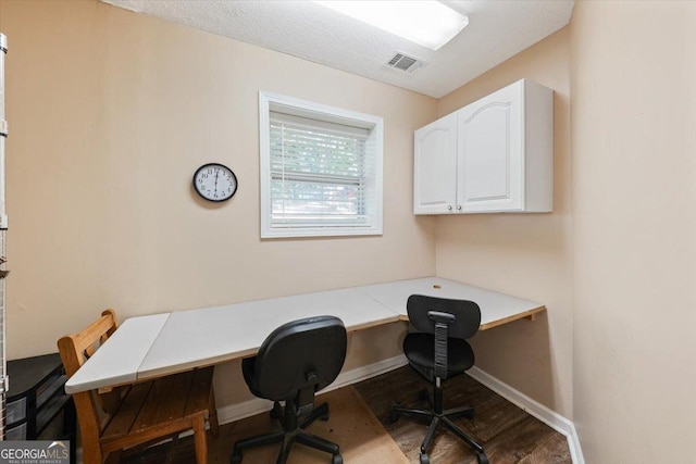 home office featuring visible vents, baseboards, and wood finished floors