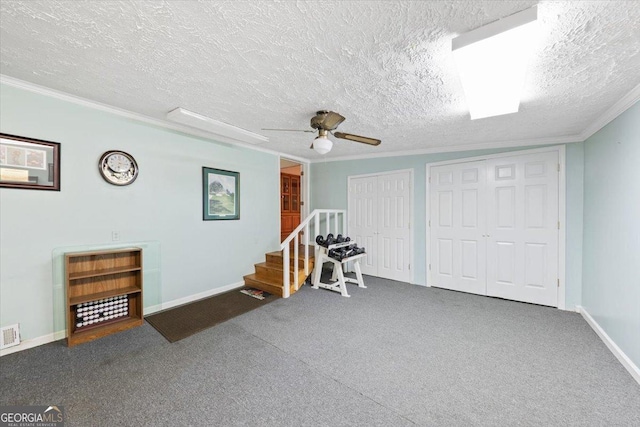 workout room featuring crown molding, visible vents, carpet flooring, ceiling fan, and a textured ceiling