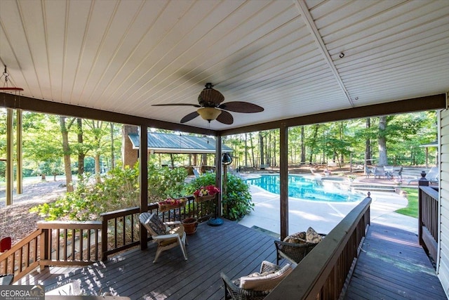 wooden deck featuring ceiling fan and an outdoor pool