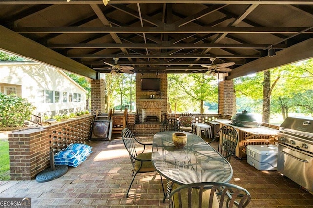 view of patio / terrace featuring an outdoor brick fireplace, outdoor dining area, exterior kitchen, and a gazebo