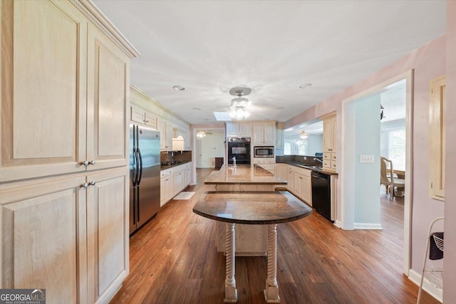 kitchen featuring ceiling fan, cream cabinets, stainless steel appliances, wood finished floors, and plenty of natural light