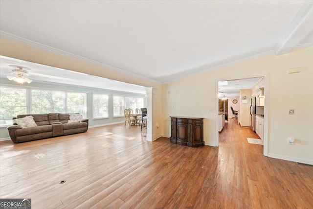 living area featuring lofted ceiling, crown molding, and wood finished floors