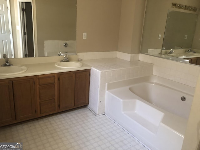 full bathroom featuring a garden tub, a sink, and tile patterned floors