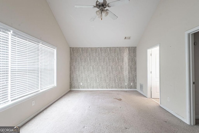 unfurnished room featuring visible vents, baseboards, a ceiling fan, an accent wall, and carpet