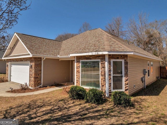 view of front facade with roof with shingles, concrete driveway, a garage, stone siding, and a front lawn