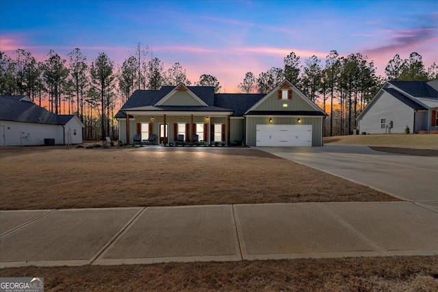 view of front of home featuring a garage, concrete driveway, a yard, and board and batten siding