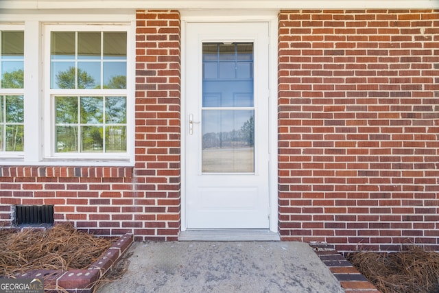 view of exterior entry with brick siding