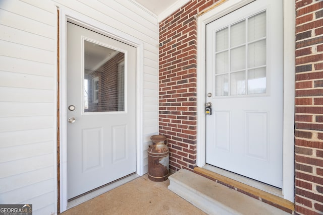 property entrance featuring a porch and brick siding