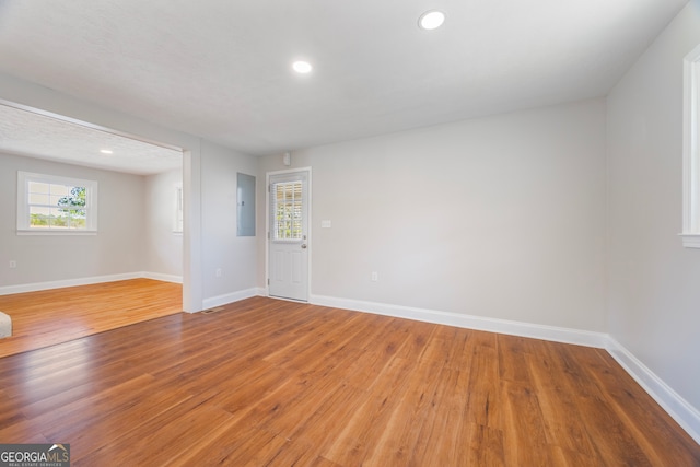 interior space featuring recessed lighting, wood finished floors, electric panel, and baseboards