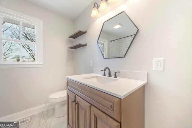 bathroom featuring marble finish floor, visible vents, toilet, vanity, and baseboards