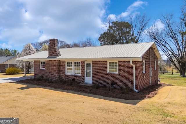 ranch-style home with brick siding, a chimney, dirt driveway, crawl space, and metal roof