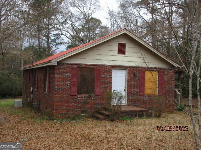 view of side of property featuring crawl space and brick siding