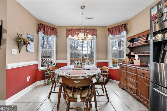 dining space featuring visible vents, a notable chandelier, baseboards, and light tile patterned flooring