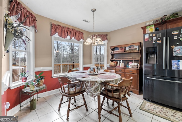 dining area featuring a chandelier, visible vents, baseboards, and light tile patterned floors