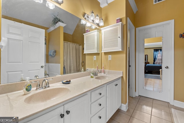 bathroom with double vanity, tile patterned flooring, baseboards, and a sink