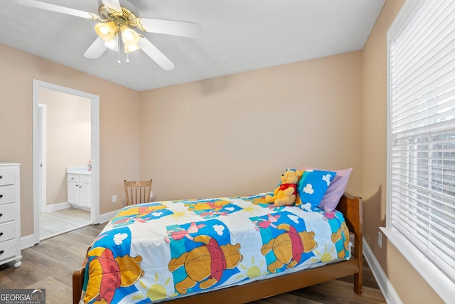 bedroom featuring ensuite bathroom, wood finished floors, a ceiling fan, and baseboards