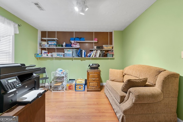 sitting room featuring visible vents and wood finished floors