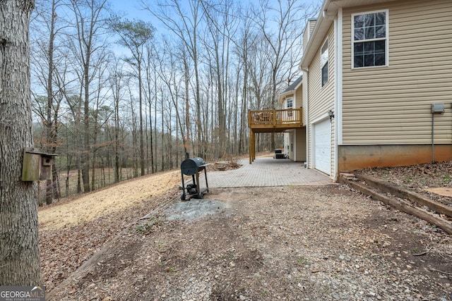 view of yard featuring a garage, driveway, and a deck