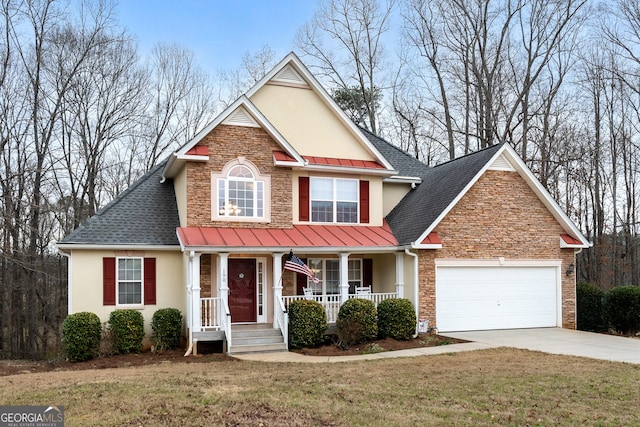 traditional home with a standing seam roof, stone siding, a porch, and stucco siding